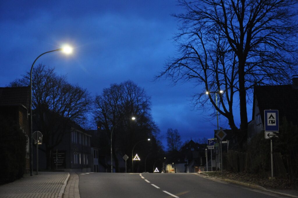 Nächtliche Dorfstraße in Clausthal-Zellerfeld mit Straßenlaternen und kahlen Bäumen im Winter