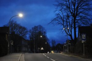 Nächtliche Dorfstraße in Clausthal-Zellerfeld mit Straßenlaternen und kahlen Bäumen im Winter