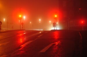Neblige Straße bei Nacht in Clausthal-Zellerfeld mit roten Ampeln und Straßenlaternen