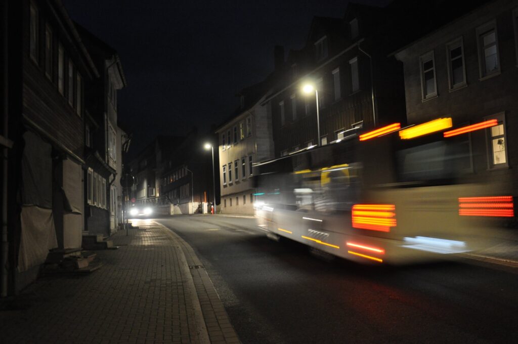 Nächtliche Straßenszene in Clausthal-Zellerfeld mit vorbeifahrendem Bus und historischen Gebäuden