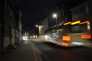 Nächtliche Straßenszene in Clausthal-Zellerfeld mit vorbeifahrendem Bus und historischen Gebäuden