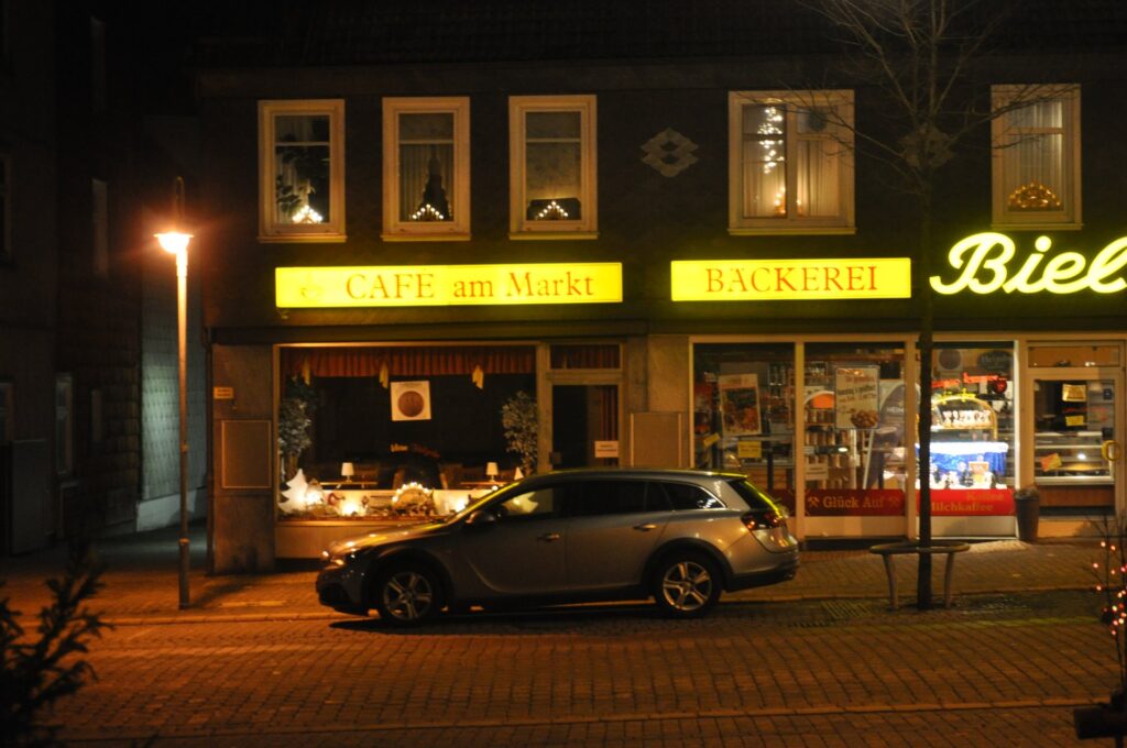 Nächtliche Straßenszene mit beleuchteten Cafés und Bäckerei in Clausthal-Zellerfeld