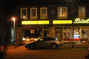 Nächtliche Straßenszene mit beleuchteten Cafés und Bäckerei in Clausthal-Zellerfeld