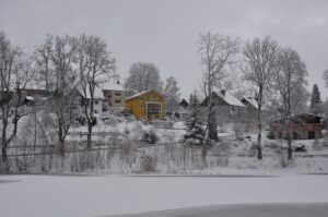 Verschneite Häuser am gefrorenen See in Clausthal-Zellerfeld im Winter