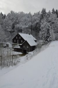Dunkles Berghaus umgeben von schneebedeckter Winterlandschaft in Clausthal-Zellerfeld