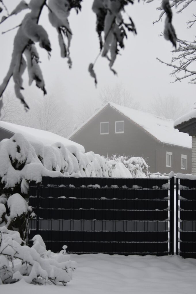 Winterlandschaft in Clausthal-Zellerfeld mit schneebedecktem Bauernhaus und Holztor