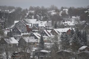 Schneebedecktes Bergdorf Clausthal-Zellerfeld mit roten und dunklen Häusern im Oberharz