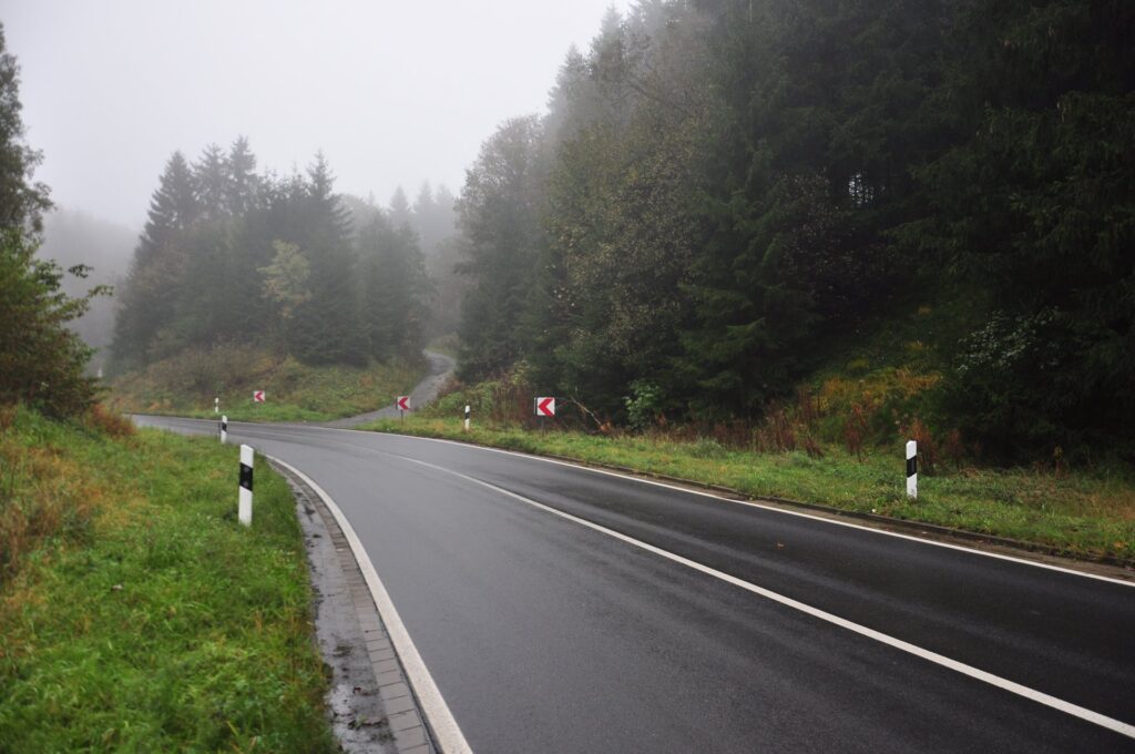 Kurvenreiche Waldstraße mit Herbstwald und Nebel in Clausthal-Zellerfeld